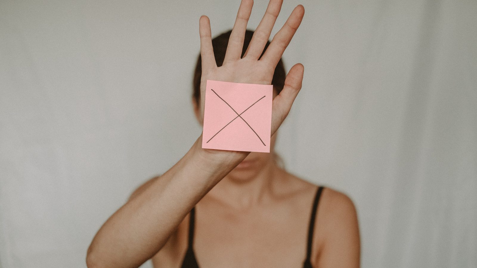 woman holding x sign